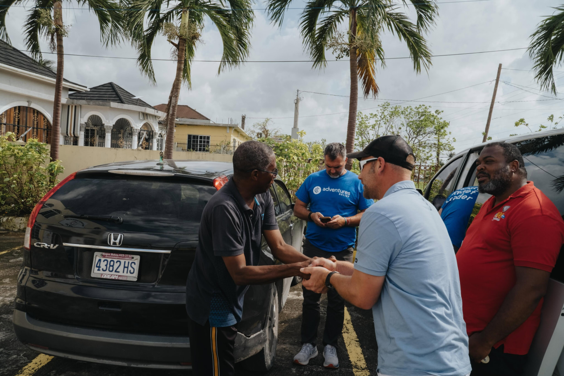 Relief leader shaking hands with a Jamaican homeowner after the storm