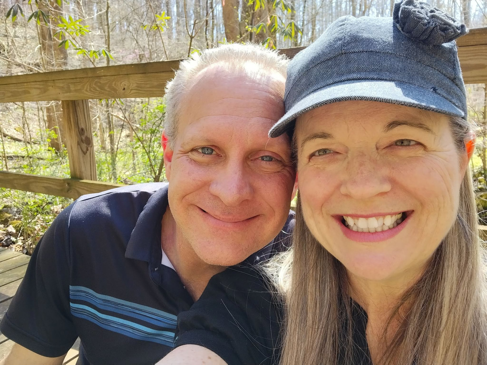 Dave and Chris Carlson smiling together outdoors on a wooded deck